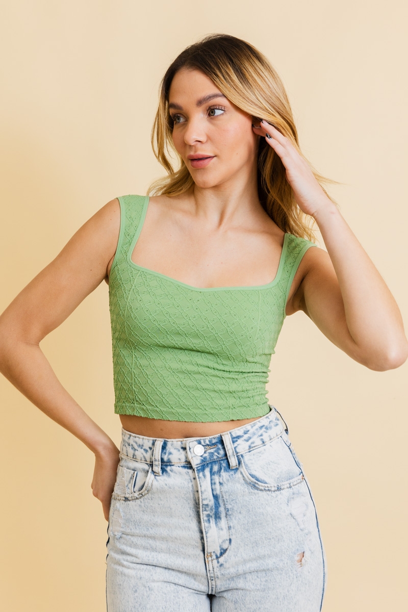 Young woman wearing green lace crop top, front view