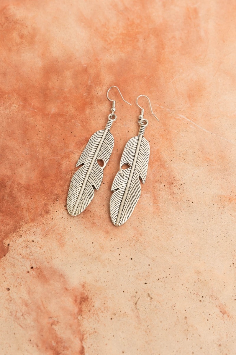 Antique silver feather dangle earrings with intricate design.