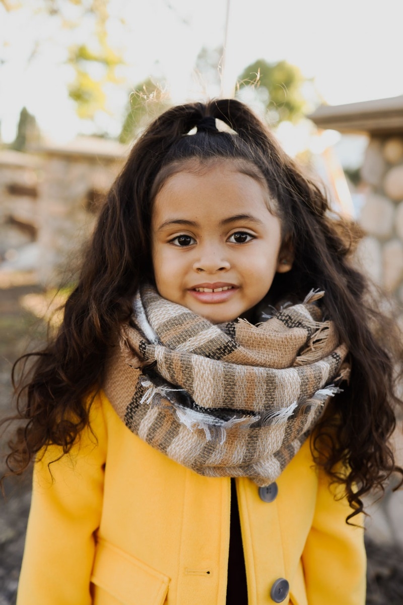 Beige flannel infinity scarf for kids, soft and cozy with frayed edges for added style.