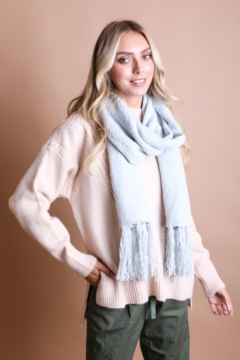 Ultra soft boucle tassel scarf in light blue, cozy winter essential with soft knit texture.